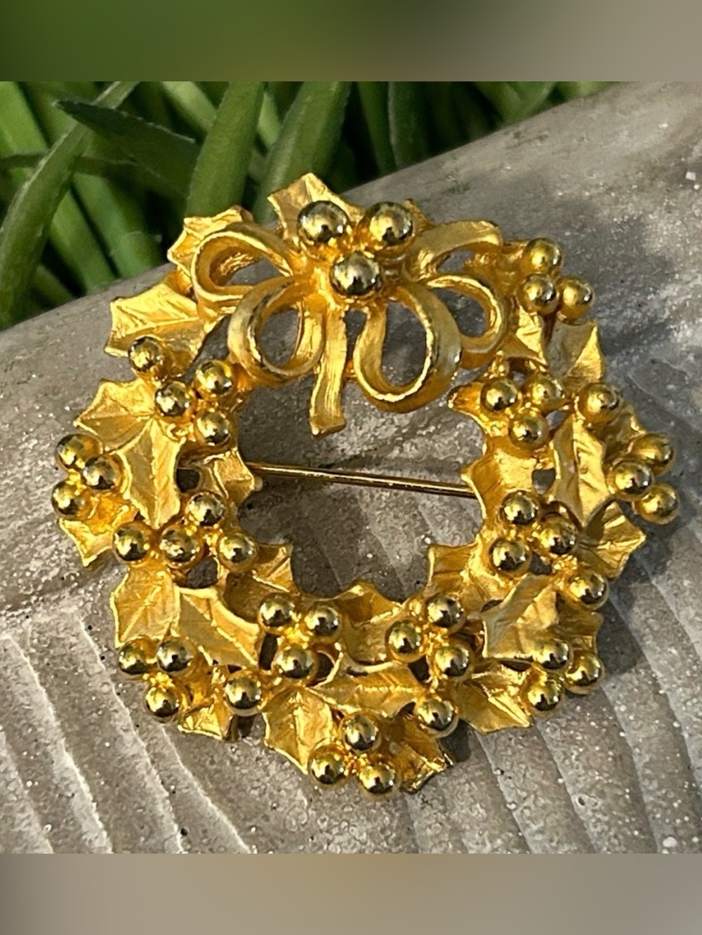 gold-tone wreath brooch with detailed holly leaves and bead accents